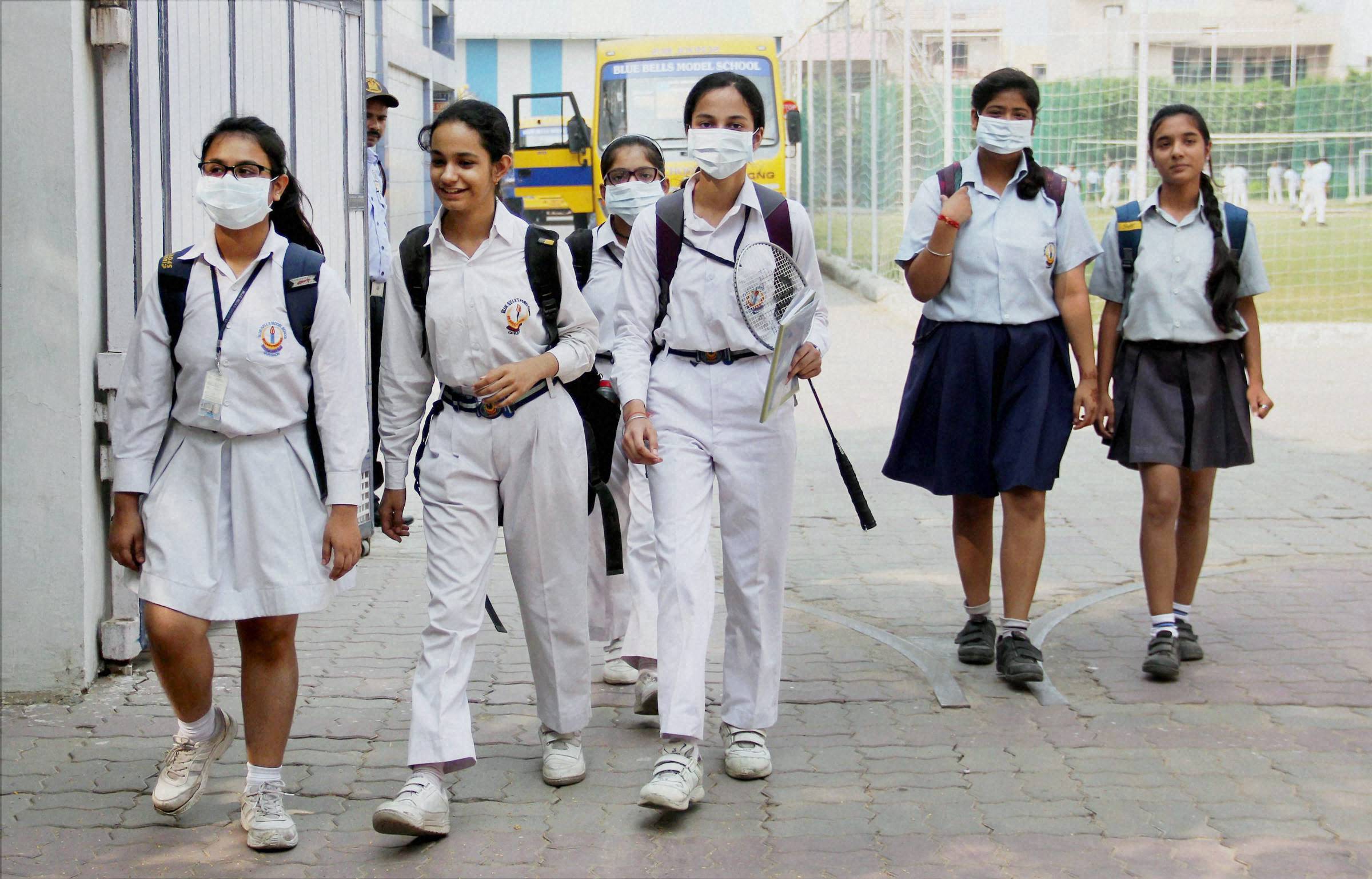 Gurgaon: School girls wear anti-air pollution mask as aprotective gear as pollution reached hazardous levels in Gurgaon on Friday. (Source: PTI)